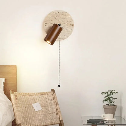 Arandela de parede moderna com base de pedra e luminária cilíndrica marrom em quarto decorado.