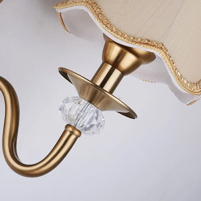 Detalhe de luminária clássica dourada com cristal lapidado e cúpula decorada
