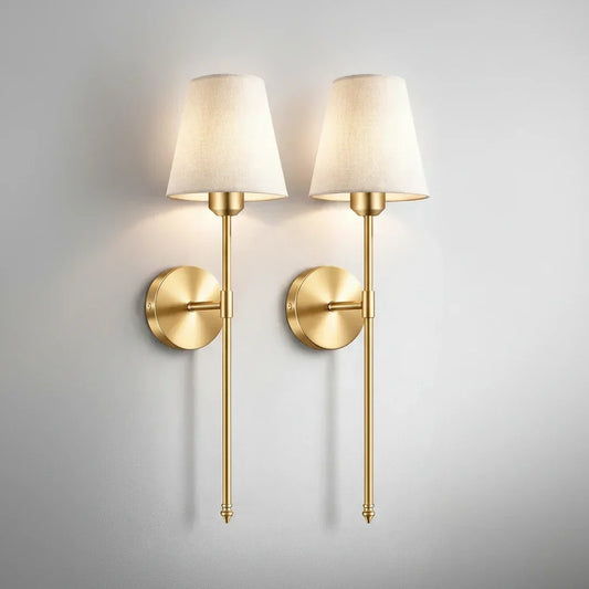 Par de arandelas de parede douradas com cúpula de tecido branco para iluminação decorativa.