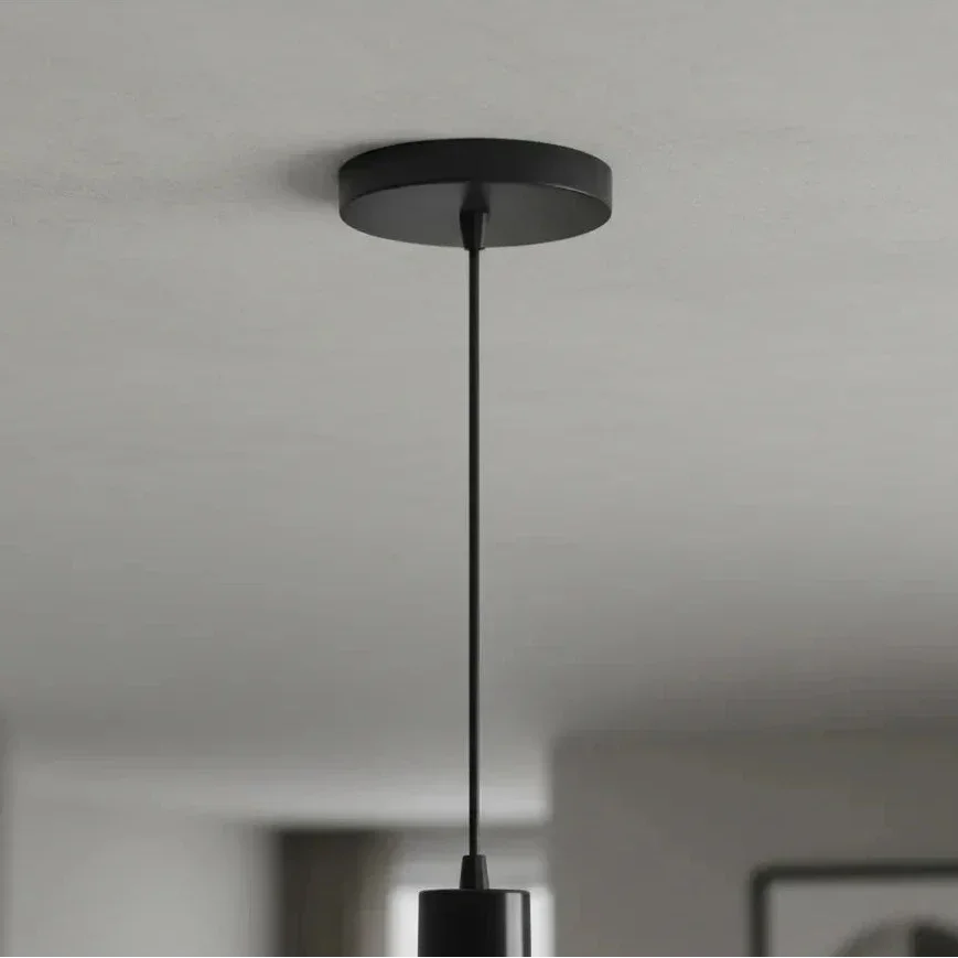 Pendente preto minimalista com cabo fino suspenso no teto branco.