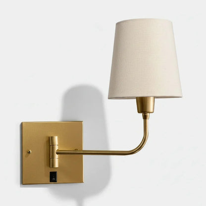 Arandela de parede dourada com cúpula de tecido bege para iluminação decorativa.