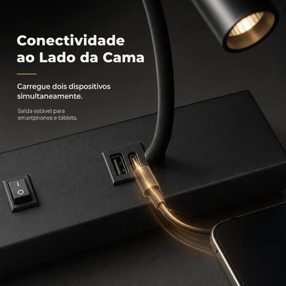 Luminária de mesa preta com portas USB para carregar smartphones e tablets ao lado da cama.